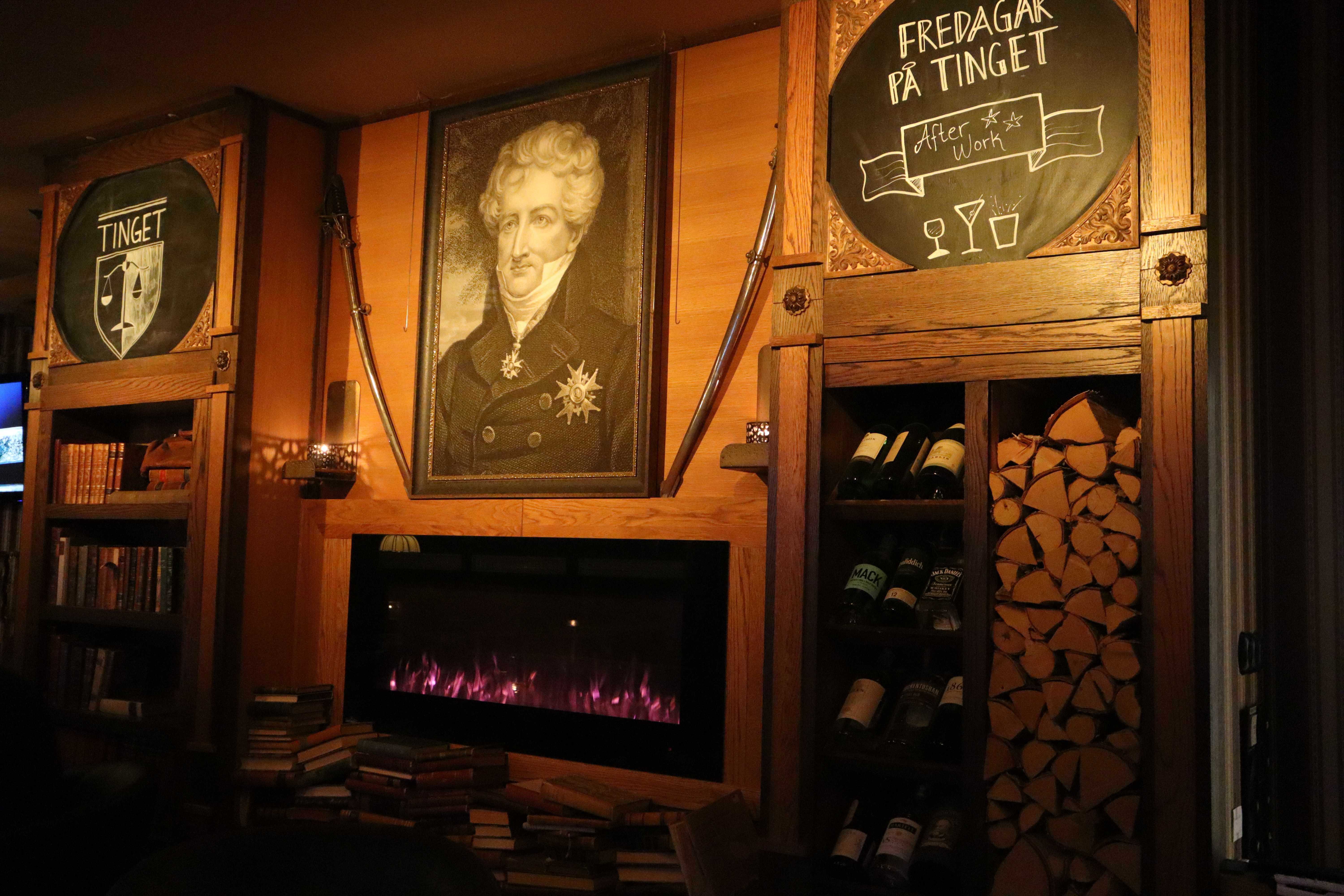Pubens vägg med öppen spis och Tinget-branding